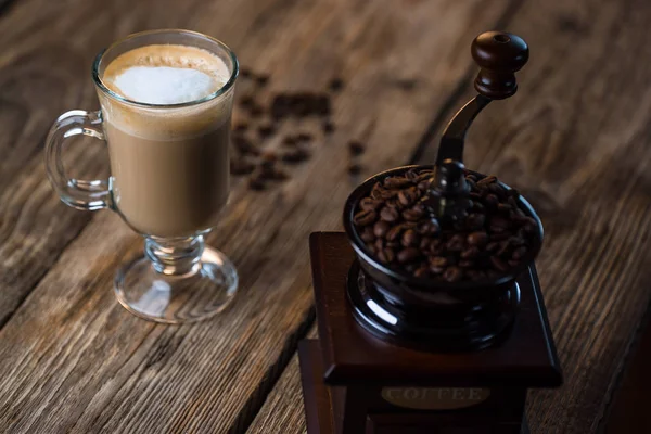 Vintage kahve öğütücü ile kavrulmuş kahve çekirdekleri ve kahve ahşap tablo