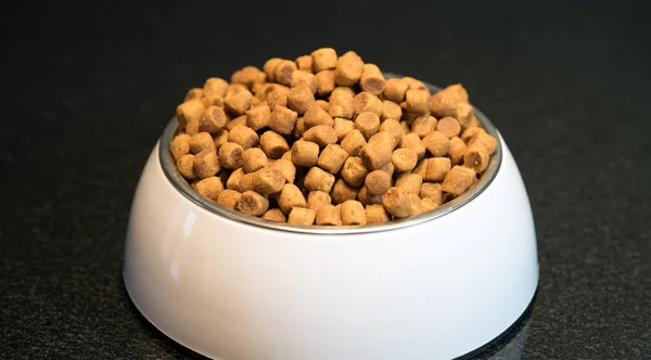 pile of dry dog food in bowl on floor