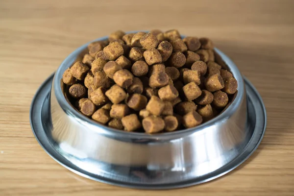 pile of dry dog food in bowl on floor