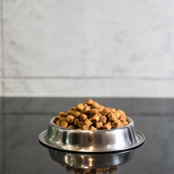 pile of dry dog food in bowl on floor