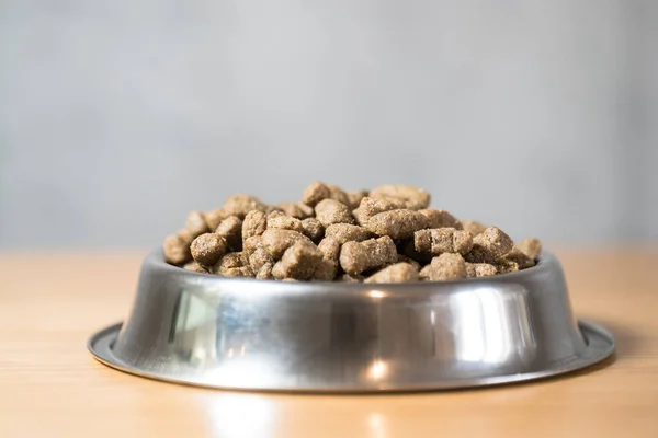 pile of dry dog food in bowl on floor