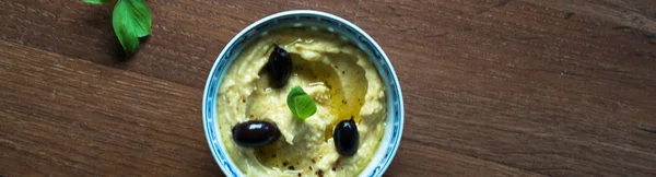 Hummus Oliwek Pieprzem Talerzu Tradycyjne Lewantyńskim Dip Liście Bazylii Stole — Zdjęcie stockowe