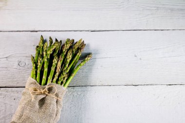 Ahşap arka plan üzerinde sağlıklı taze yeşil kuşkonmaz