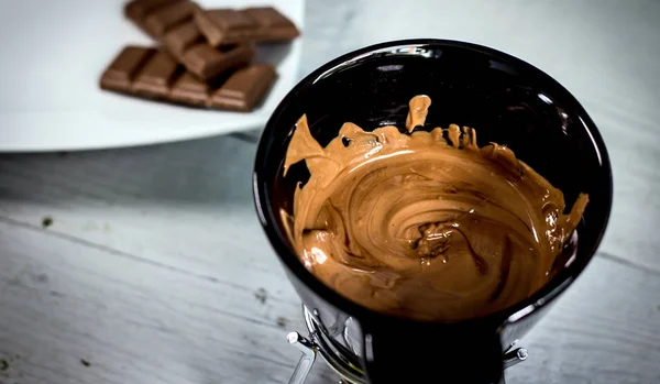 Little black bucket with melted milk chocolate