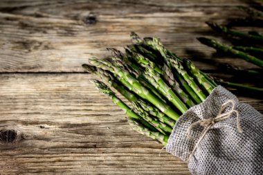 Ahşap arka plan üzerinde sağlıklı taze yeşil kuşkonmaz