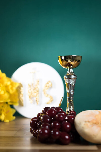 Христограмма IHS на белом фоне с чашкой
