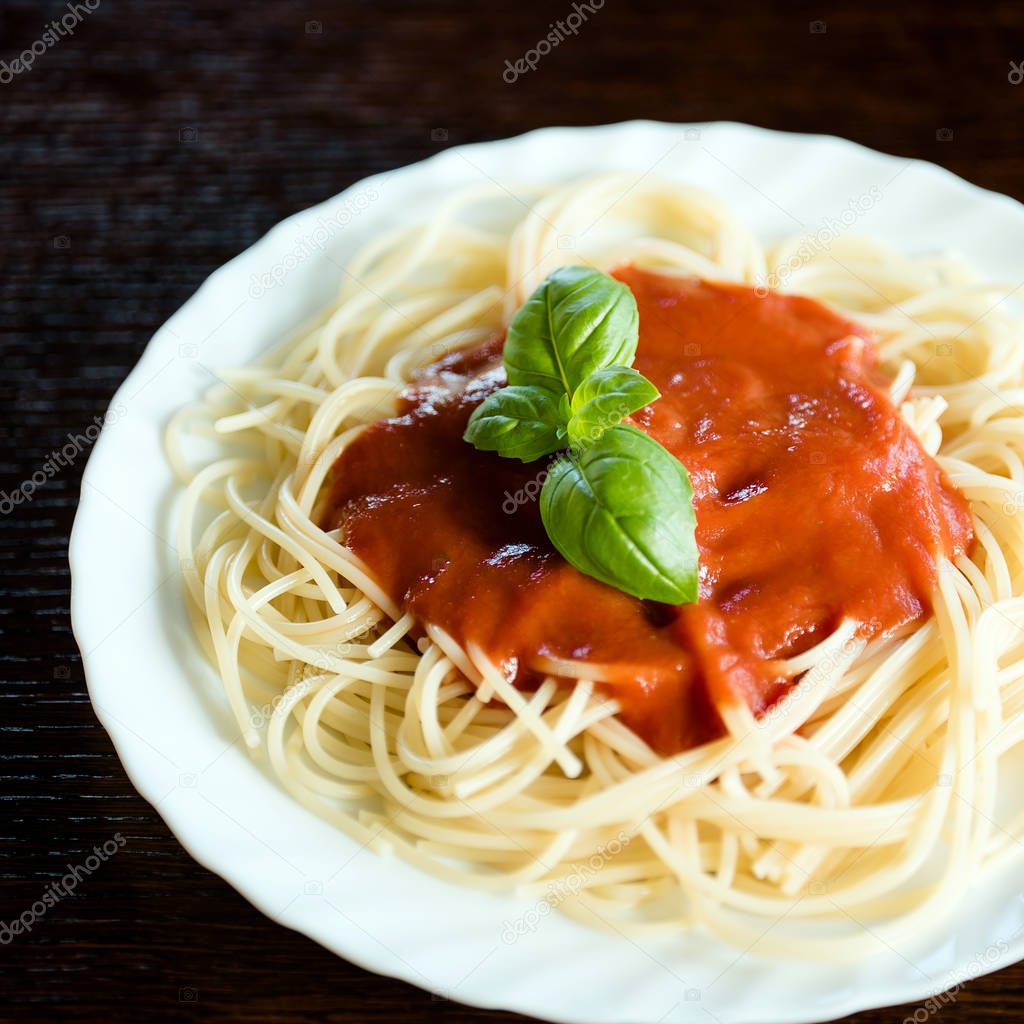 Italian pasta with tomato sauce and basil leaves