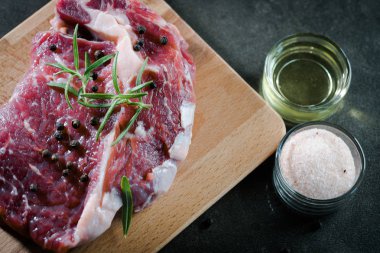 Çiğ biftek et baharatlar ile kara tahta üzerinde kapat