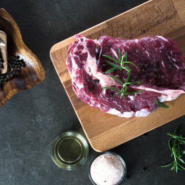 Çiğ biftek et baharatlar ile kara tahta üzerinde kapat