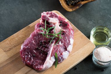 Çiğ biftek et baharatlar ile kara tahta üzerinde kapat