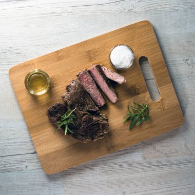 Otlar ile kara tahta üzerinde biftek dilimlenmiş apetisant