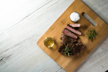 Otlar ile kara tahta üzerinde biftek dilimlenmiş apetisant