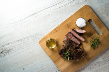 Otlar ile kara tahta üzerinde biftek dilimlenmiş apetisant