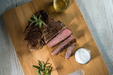 Otlar ile kara tahta üzerinde biftek dilimlenmiş apetisant