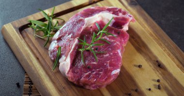 Çiğ otlar ile kara tahta üzerinde biftek et parçası