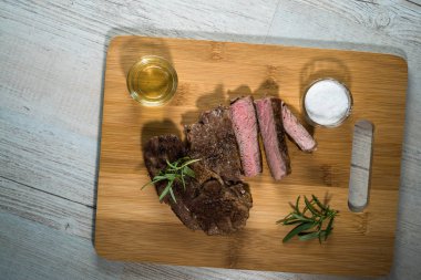 Otlar ile kara tahta üzerinde biftek dilimlenmiş apetisant