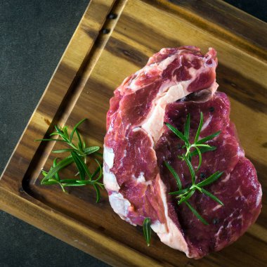 Çiğ otlar ile kara tahta üzerinde biftek et parçası