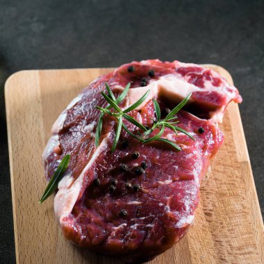 Çiğ otlar ile kara tahta üzerinde biftek et parçası