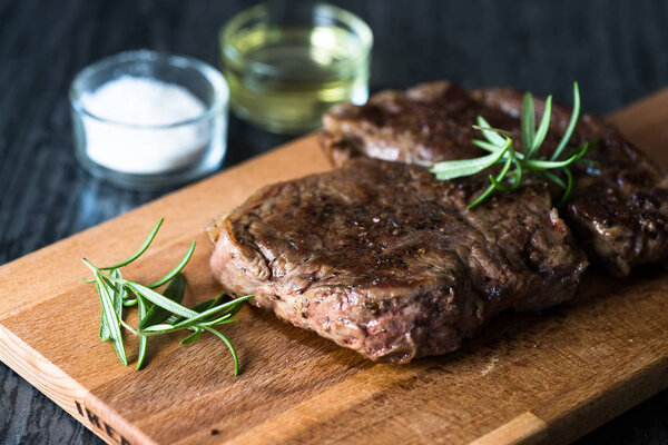 Appetizing steak on chalkboard with herbs and spices