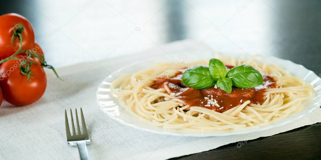 Italian pasta with tomato sauce and basil leaves