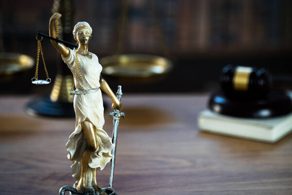 Статуя слепой богини Фемиды на размытом фоне
