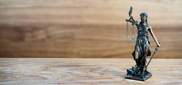 Статуя слепой богини Фемиды на размытом фоне
