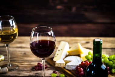 Ahşap arka planda üzüm ve şarap ile iştah açıcı peynir