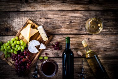 Ahşap arka planda üzüm ve şarap ile iştah açıcı peynir