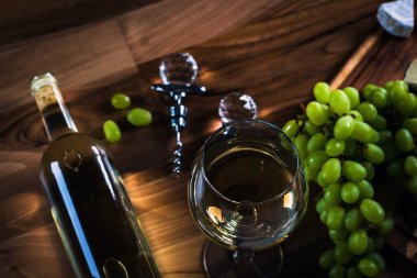 Ahşap arka planda üzüm ve şarap ile iştah açıcı peynir