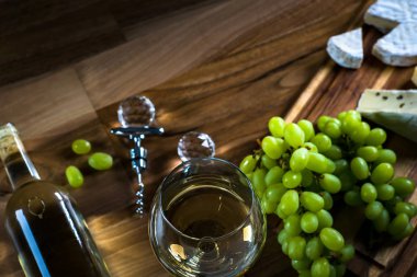 Ahşap arka planda üzüm ve şarap ile iştah açıcı peynir