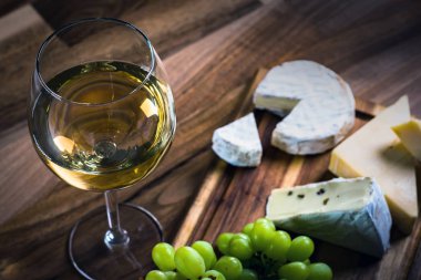 Ahşap arka planda üzüm ve şarap ile iştah açıcı peynir