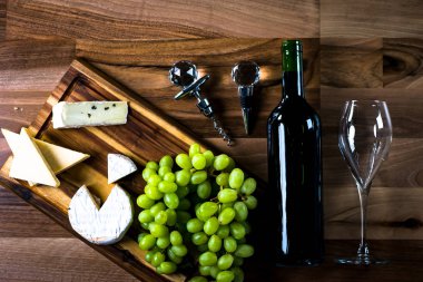 Ahşap arka planda üzüm ve şarap ile iştah açıcı peynir