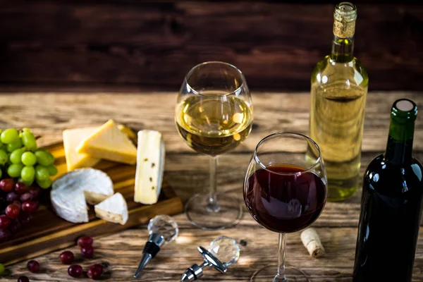 Ahşap arka planda üzüm ve şarap ile iştah açıcı peynir