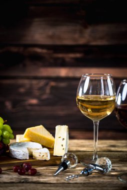 Ahşap arka planda üzüm ve şarap ile iştah açıcı peynir