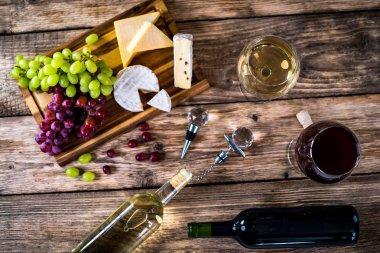 Ahşap arka planda üzüm ve şarap ile iştah açıcı peynir