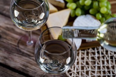 Ahşap arka planda üzüm ve şarap ile iştah açıcı peynir