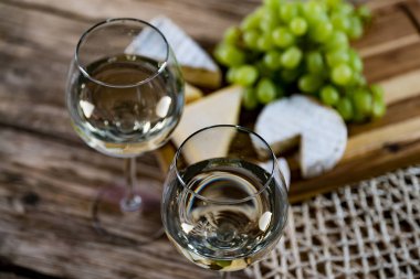 Ahşap arka planda üzüm ve şarap ile iştah açıcı peynir