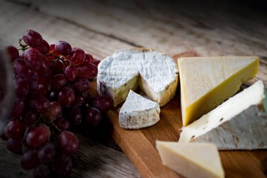 Ahşap arka planda üzüm ile iştah açıcı peynir