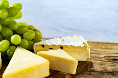 Ahşap arka planda üzüm ile iştah açıcı peynir