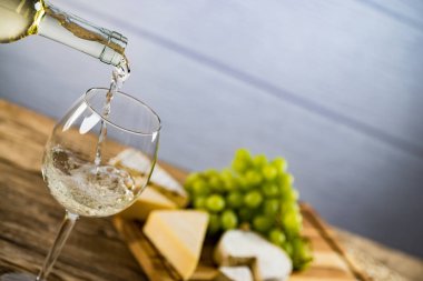 Ahşap arka planda üzüm ve şarap ile iştah açıcı peynir