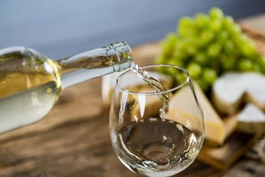 Ahşap arka planda üzüm ve şarap ile iştah açıcı peynir