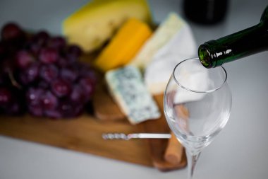 Ahşap arka planda üzüm ve şarap ile iştah açıcı peynir