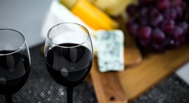 Ahşap arka planda üzüm ve şarap ile iştah açıcı peynir