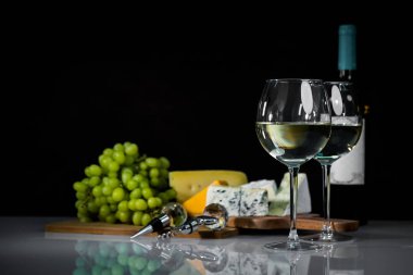 Ahşap arka planda üzüm ve şarap ile iştah açıcı peynir