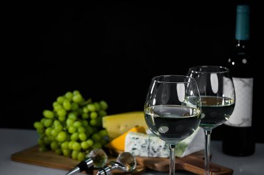 Ahşap arka planda üzüm ve şarap ile iştah açıcı peynir