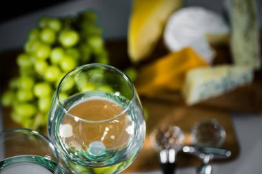 Ahşap arka planda üzüm ve şarap ile iştah açıcı peynir