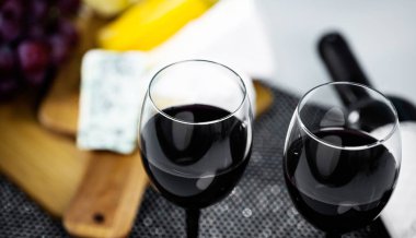 Ahşap arka planda üzüm ve şarap ile iştah açıcı peynir