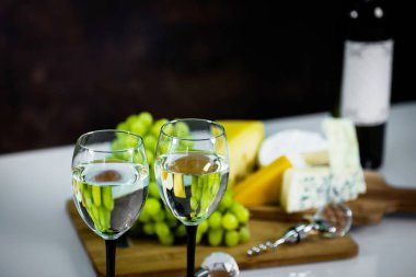 Ahşap arka planda üzüm ve şarap ile iştah açıcı peynir