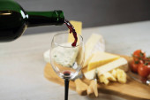 Appetifikující sýr s hrozny a vínem na dřevěném pozadí