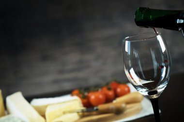 Ahşap arka planda üzüm ve şarap ile iştah açıcı peynir
